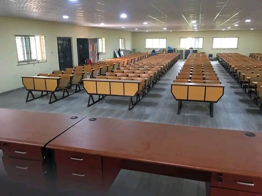 Tiered lecture theatre seating with timber writing surfaces on steel frames, manufactured and installed by Abytech